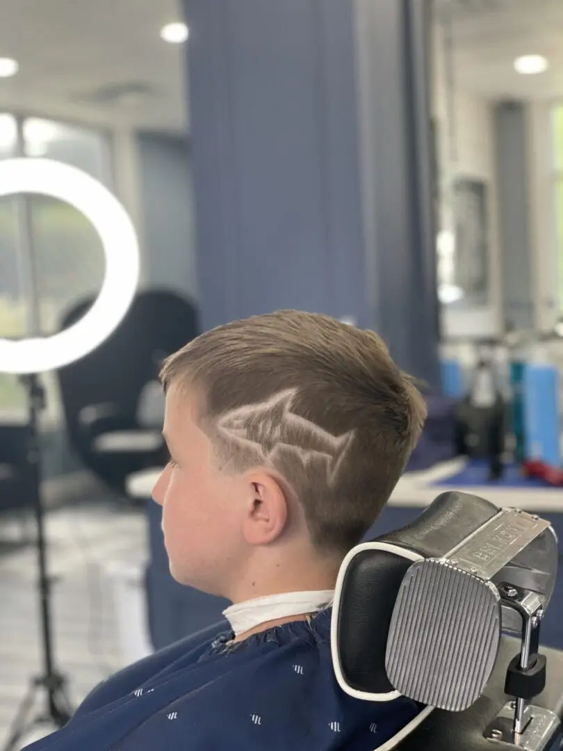 A boy with a shark tattoo on his head.