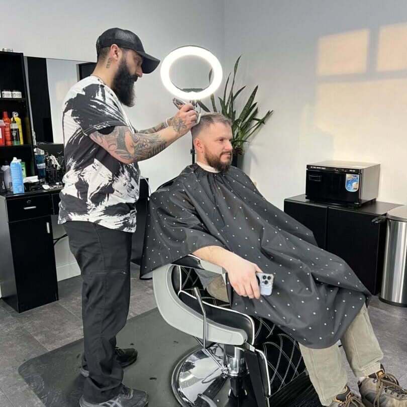 A man getting his hair cut by a barber